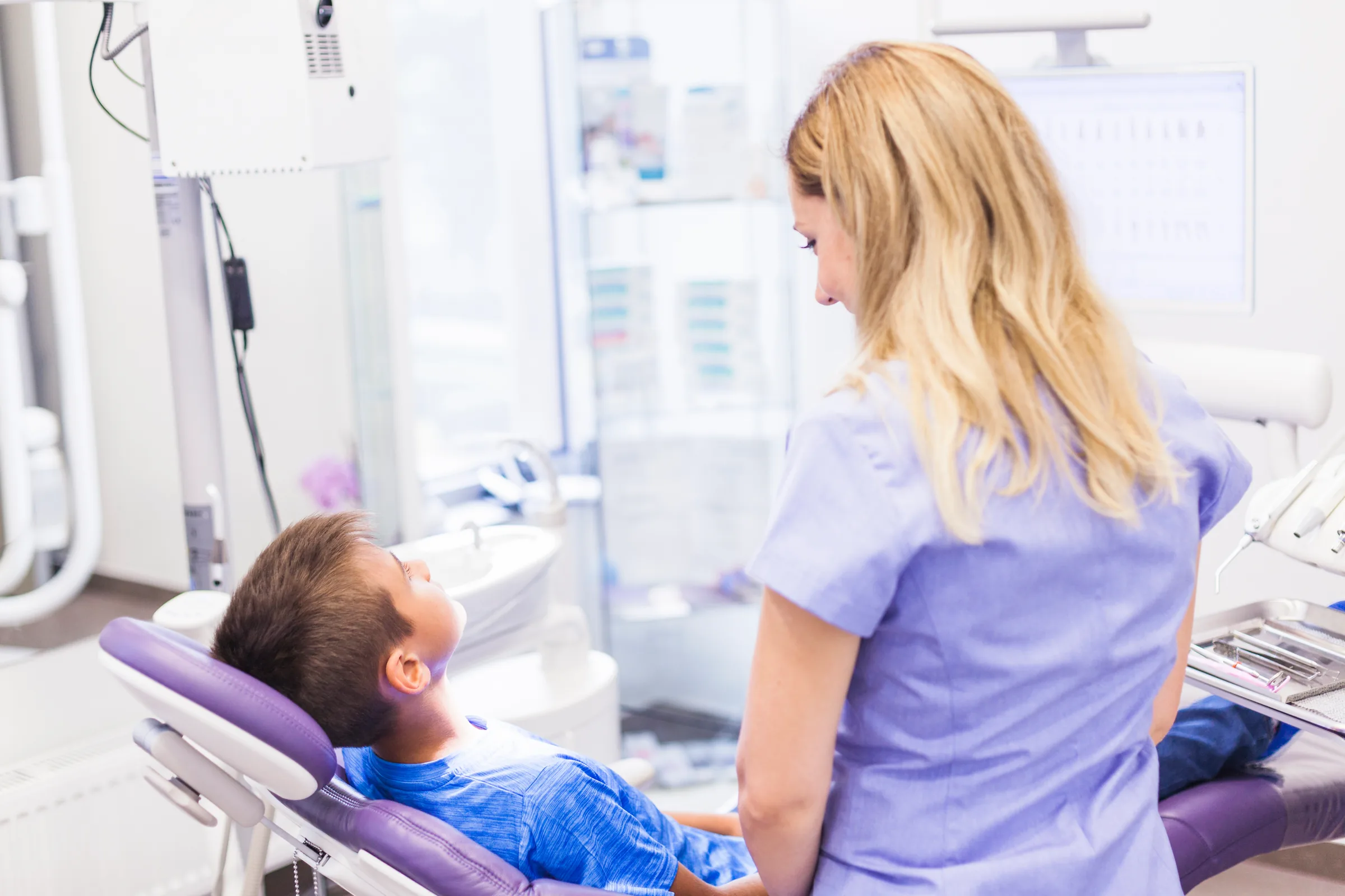 Dentist speaking with a child and parent about children's dental care